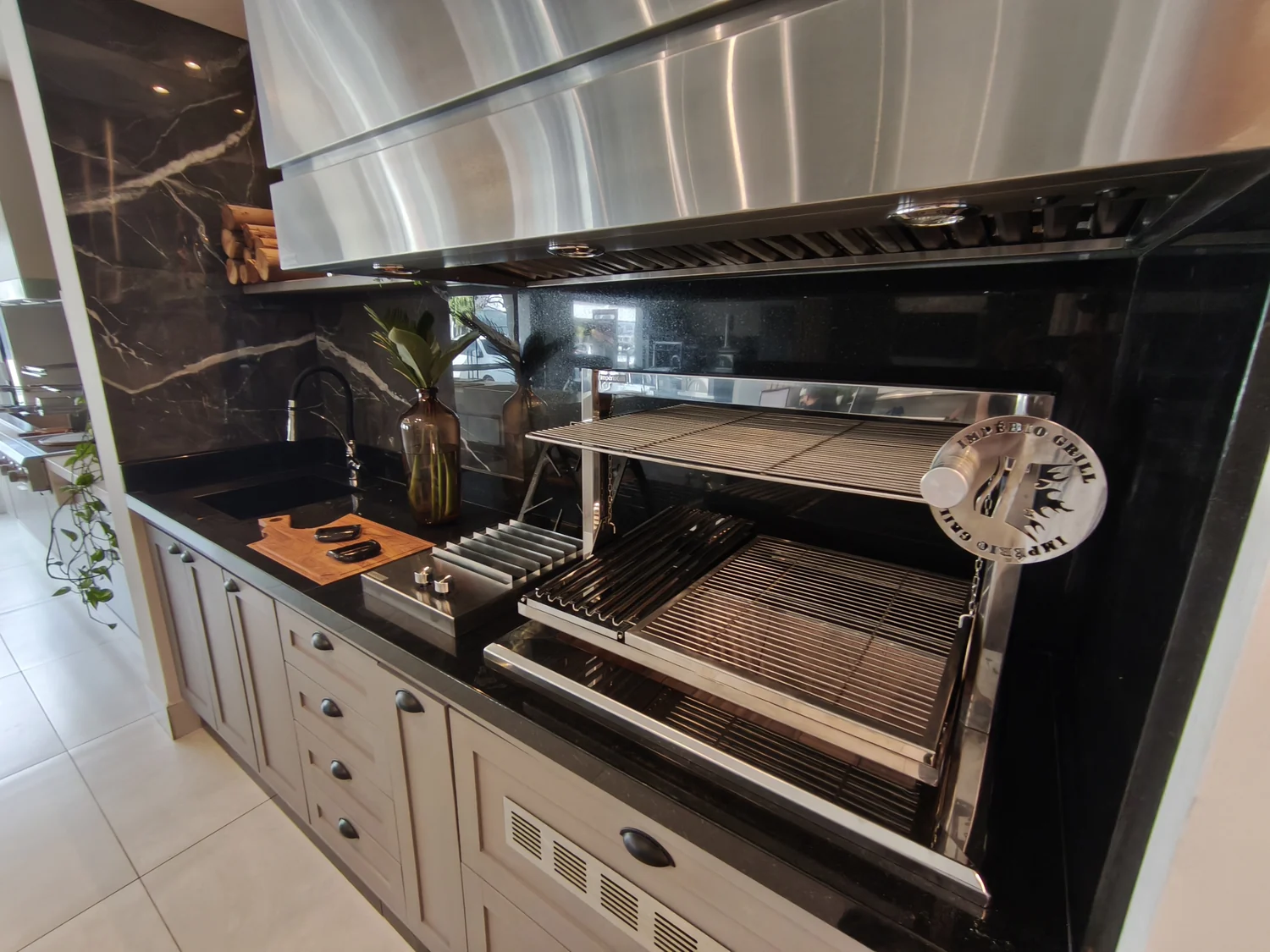 Churrasqueira gourmet em inox integrada a uma cozinha planejada