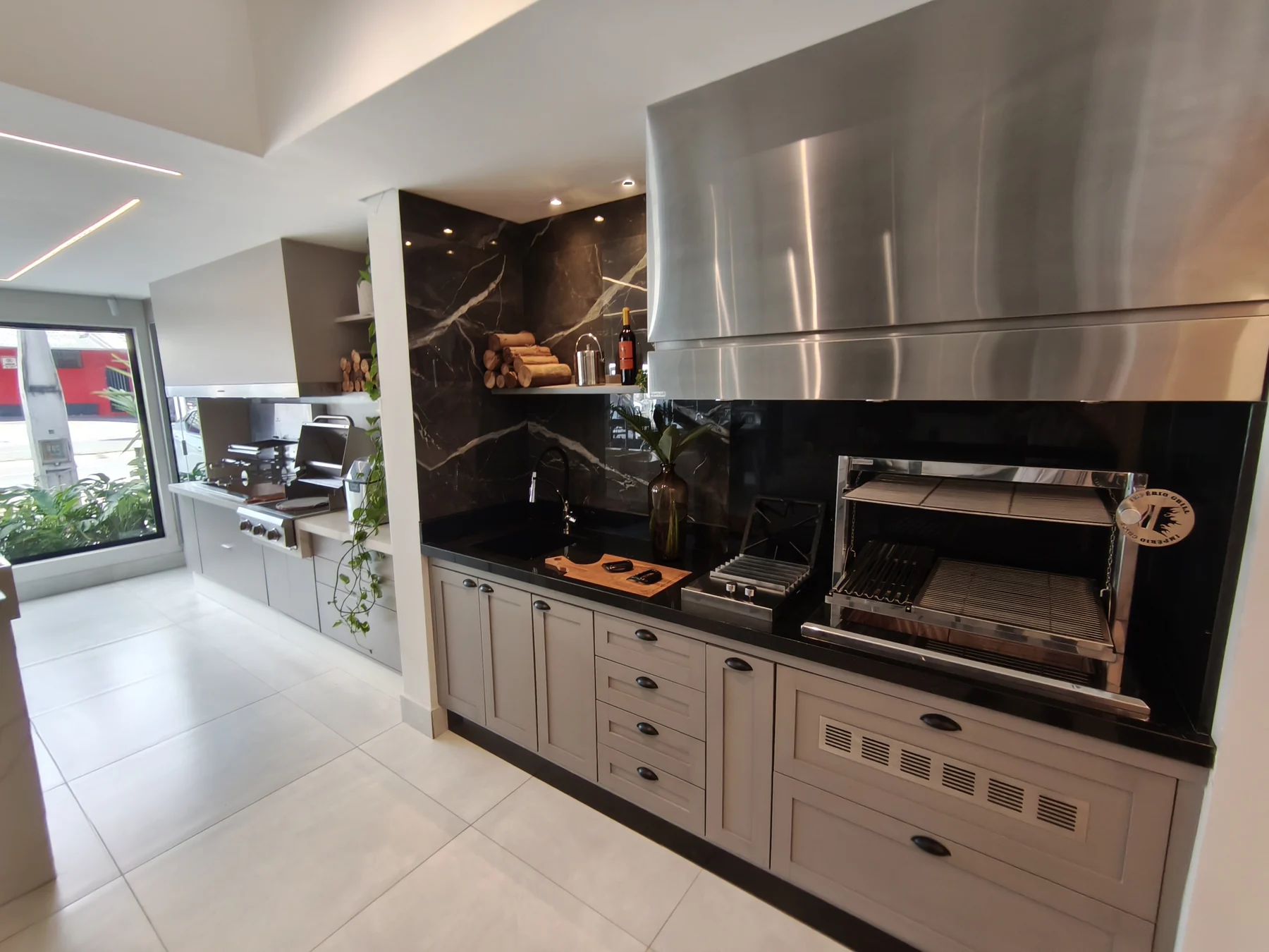 Cozinha gourmet integrada com churrasqueira e coifa em inox