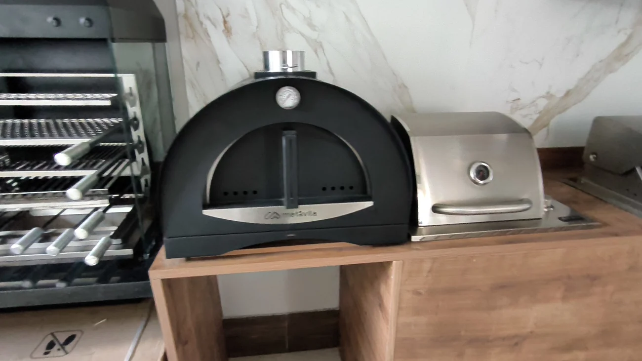 Forno a lenha preto integrado à bancada de madeira